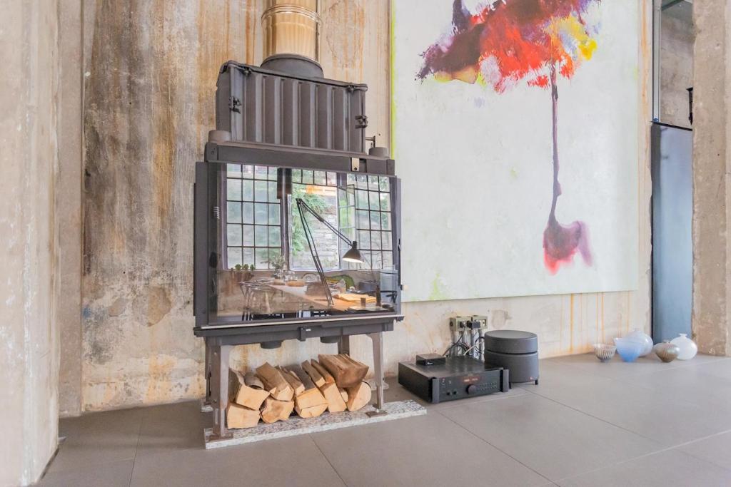 a wood stove with logs in a room at Design Loft with Private Parking by Rent All Como in Como