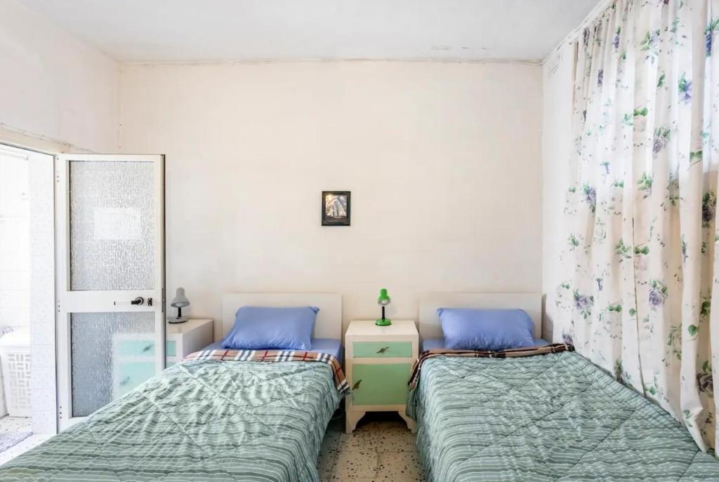 a bedroom with two beds and a window at Town House - Private Rooms - Near Sea in Il-Gżira