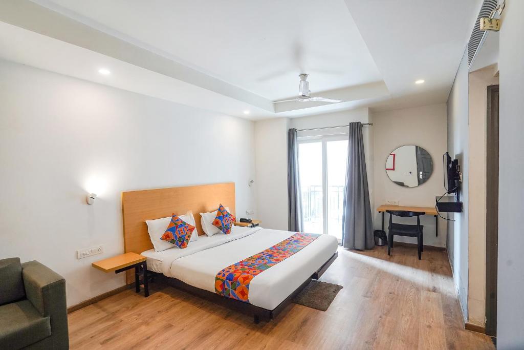 um quarto com uma cama e uma secretária num quarto em FabHotel Prime Cloud 9 em Ghaziabad