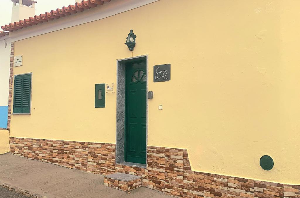 een gebouw met een groene deur aan de zijkant bij Casa da Avó Pipa in Reguengos de Monsaraz