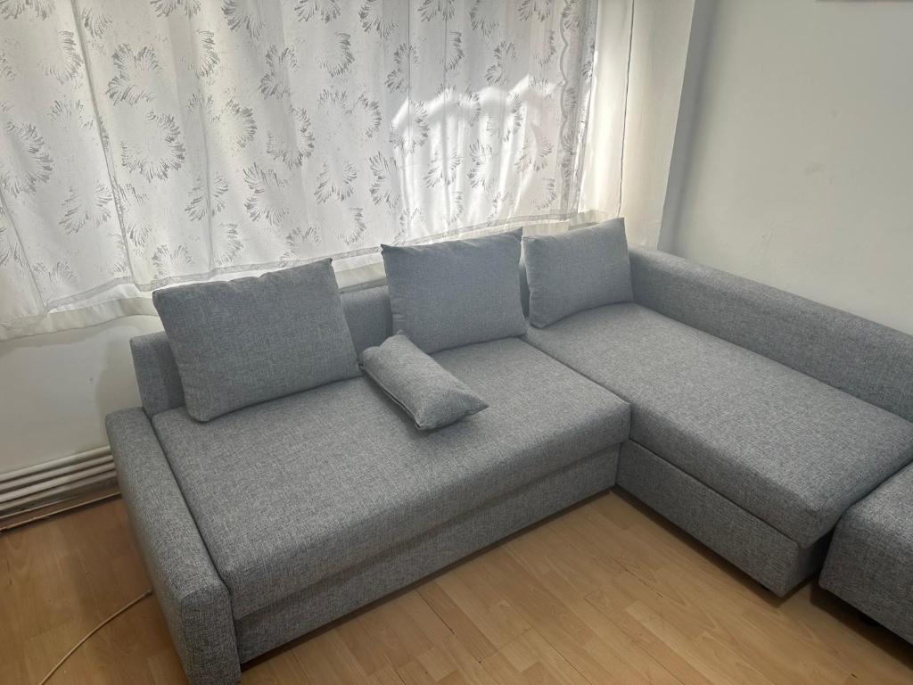 a gray couch in a room with a window at 1+1 Flat in Fatih Aksaray in Istanbul
