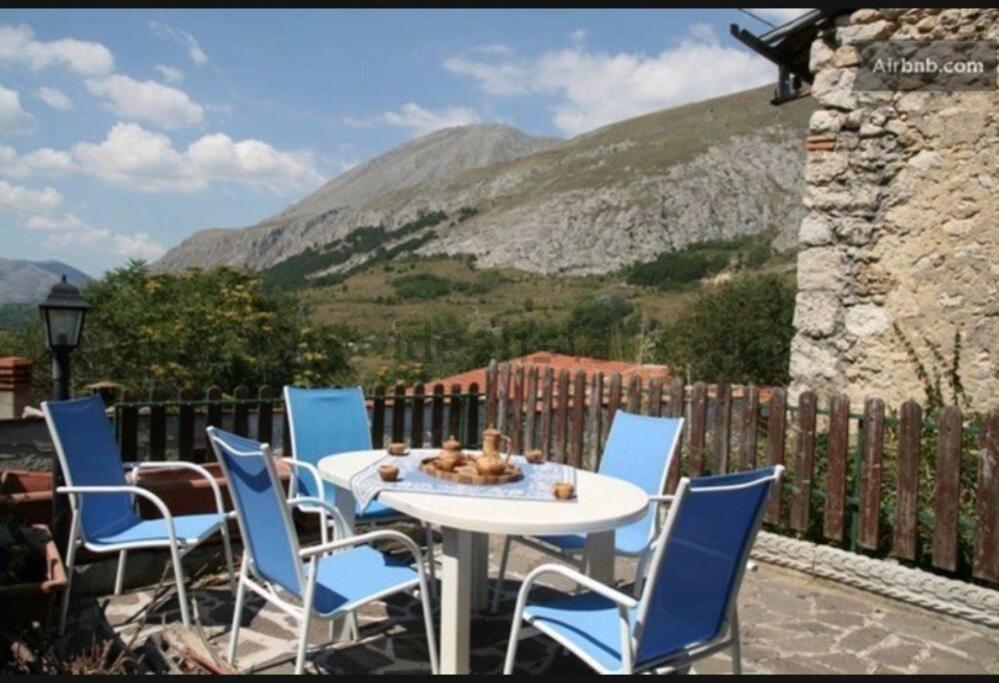 einen Tisch und Stühle auf einer Terrasse mit einem Berg in der Unterkunft Oasi nel borgo in Aielli