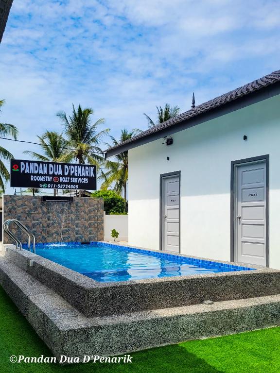 a swimming pool in front of a house at Pandan Dua D'Penarik in Kampong Ru Sepuloh