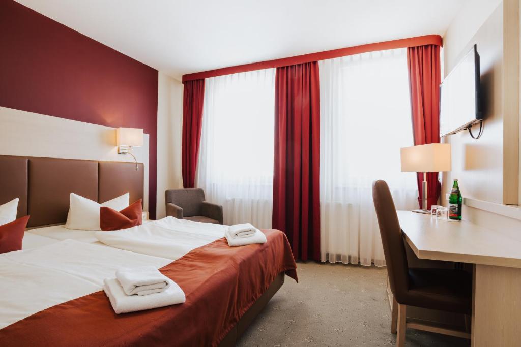 une chambre d'hôtel avec un lit et 2 serviettes. dans l'établissement Hotel & Restaurant Wiggers, à Bad Oldesloe