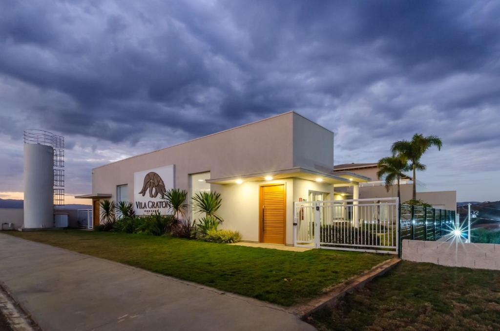 a white house with a yellow door at night at Pousada Vila Craton Canastra in São João Batista do Glória