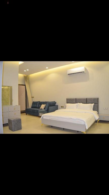 a bedroom with a large bed and a couch at شاليهات ورد المساء in Taif