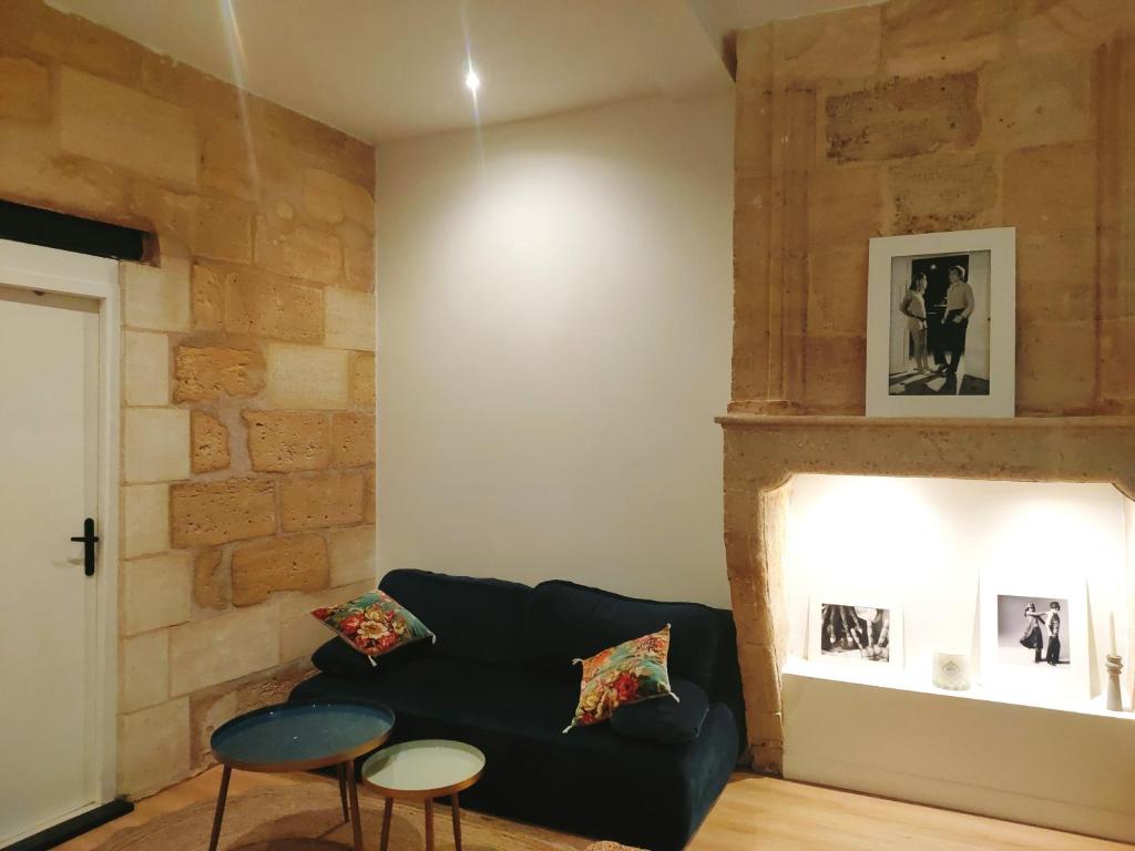 a living room with a black couch and a brick wall at Modern Flat Historic Center in Bordeaux