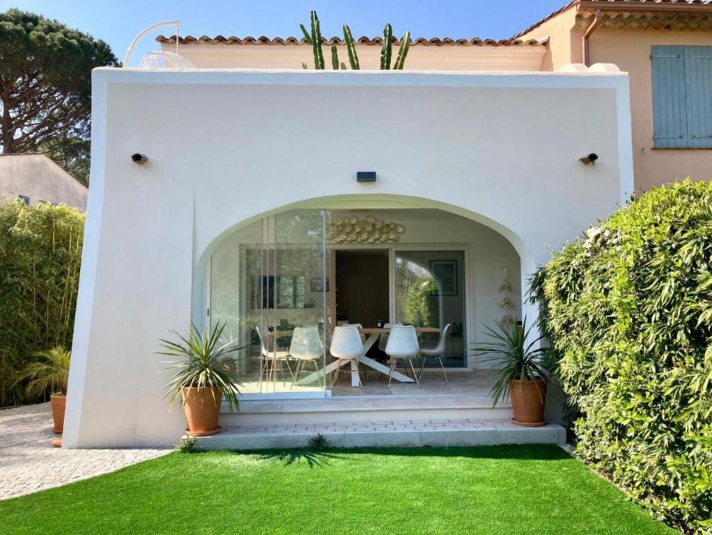 une maison blanche avec une pelouse verte dans l'établissement Villa Les Chênes Les Restanques du Golfe de St Tropez, à Grimaud