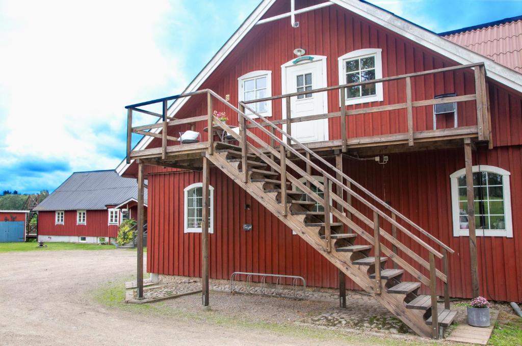 a red barn with a staircase on the side of it at Ängagården - Gårdslyckan in Våxtorp