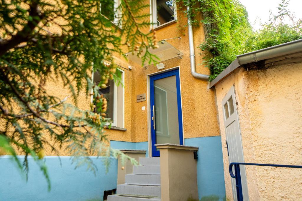 um edifício com uma porta azul e escadas em frente em FEWO in Weimar mit Garten am Schwanseebad em Weimar
