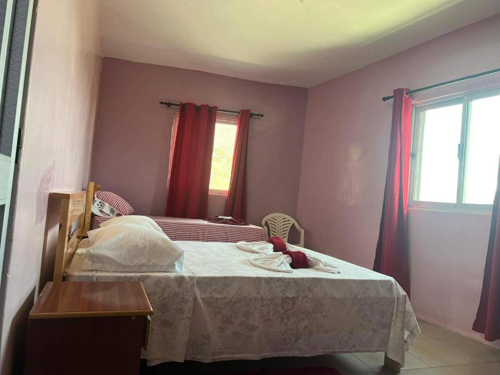 a bedroom with a bed with a table and a window at Casa Ze & sonia in Portela