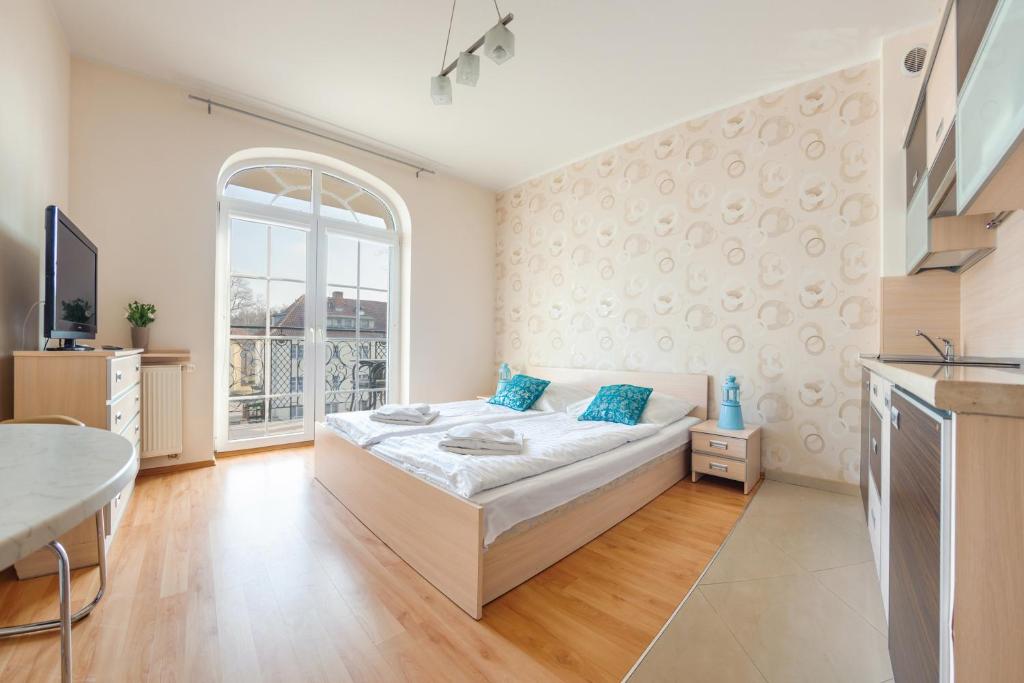 - une chambre avec un lit et une grande fenêtre dans l'établissement Apartamenty Sun & Snow Promenada II, à Świnoujście