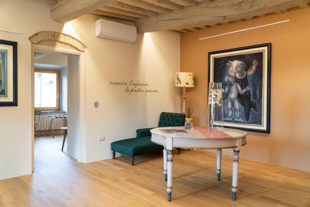 una habitación con una mesa y una pintura en la pared en Losanna Suites, en Campiglia Marittima