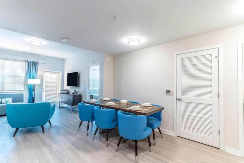 a dining room with a table and blue chairs at TVPM-4OO1#2O3BD VC apts in Orlando