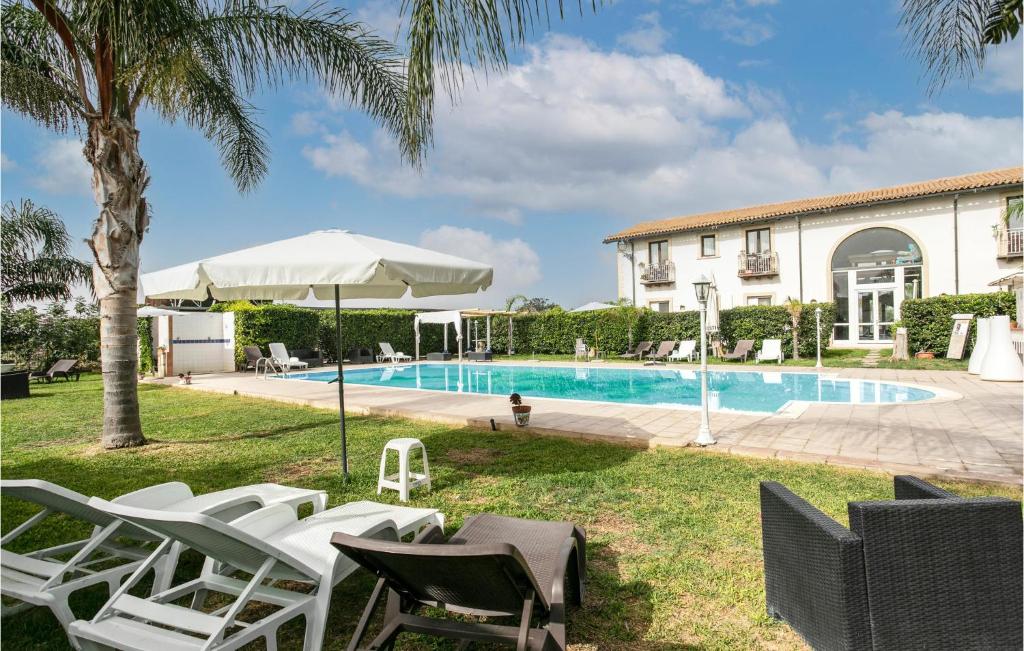 a villa with a swimming pool and lounge chairs at Cozy Home In Arenella With Outdoor Swimming Pool in Arenella