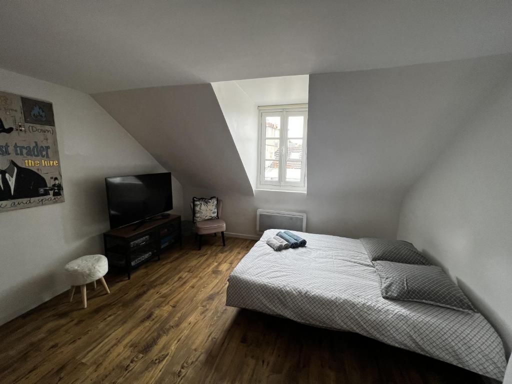 a bedroom with a bed and a flat screen tv at Sweet Abreuvoir in Saint-Germain-en-Laye