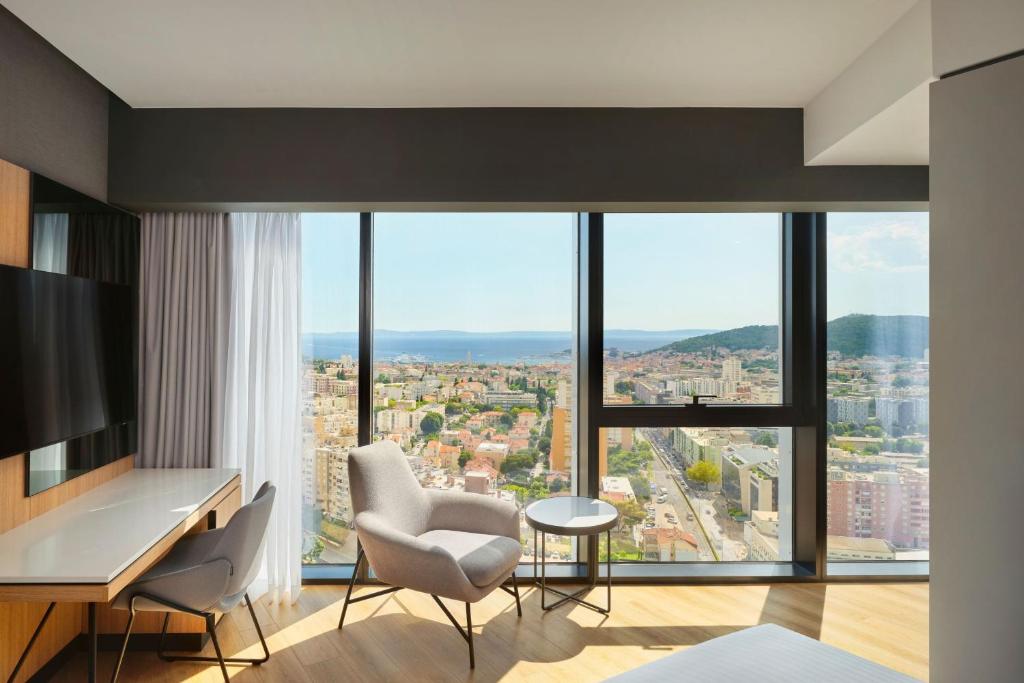 una camera con scrivania, sedie e una grande finestra di AC Hotel by Marriott Split a Spalato (Split)