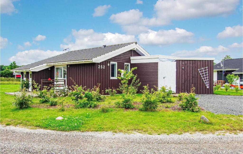 una pequeña casa con un jardín frente a ella en Stunning Home In Juelsminde With 2 Bedrooms And Wifi en Sønderby