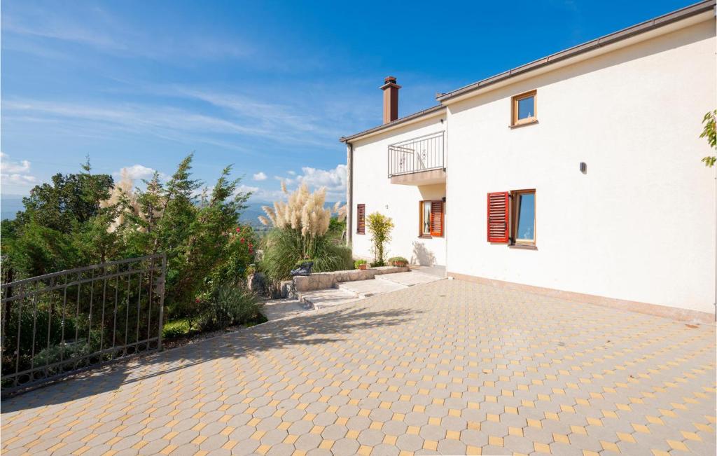 a white house with a brick driveway at Stunning Home In Vinjani Donji With 5 Bedrooms, Wifi And Outdoor Swimming Pool in Majići