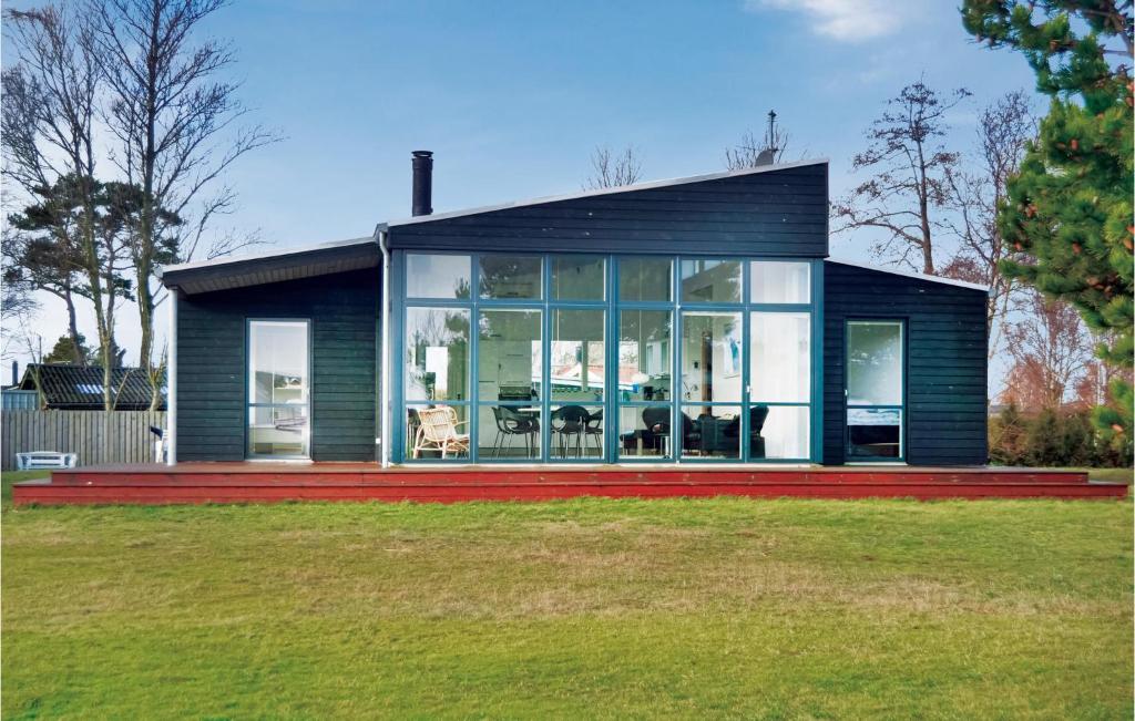 SønderbyにあるStunning Home In Juelsminde With 3 Bedrooms, Sauna And Wifiの大きな窓のある小さな黒い家