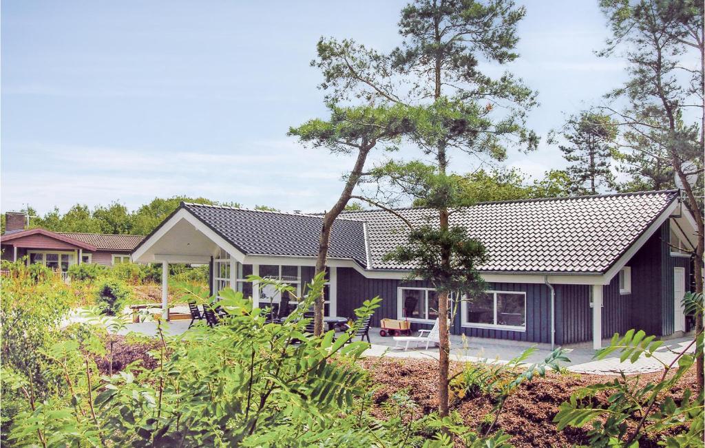 Fjellerup StrandにあるAwesome Home In Glesborg With 4 Bedrooms, Sauna And Wifiの青い外観と木々のある家