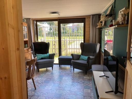 - un salon avec des chaises, un canapé et une table dans l'établissement Aan de Dijk, à Dordrecht