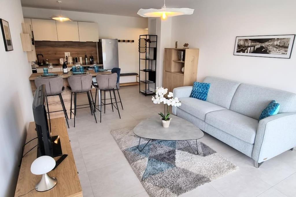 een woonkamer met een bank en een tafel bij Appartement Neuf, Superbe Déco, 2 chambres, Centre historique, 2 Parkings Privés in Sète