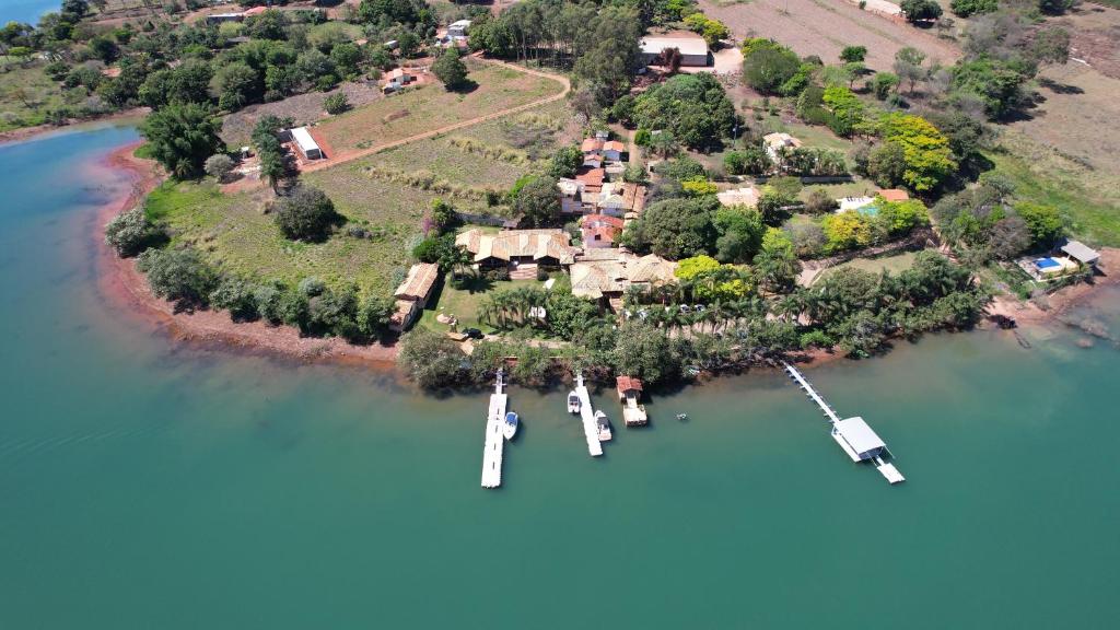 uma ilha com dois barcos na água em Pousada do Lago Dutra em Guapé