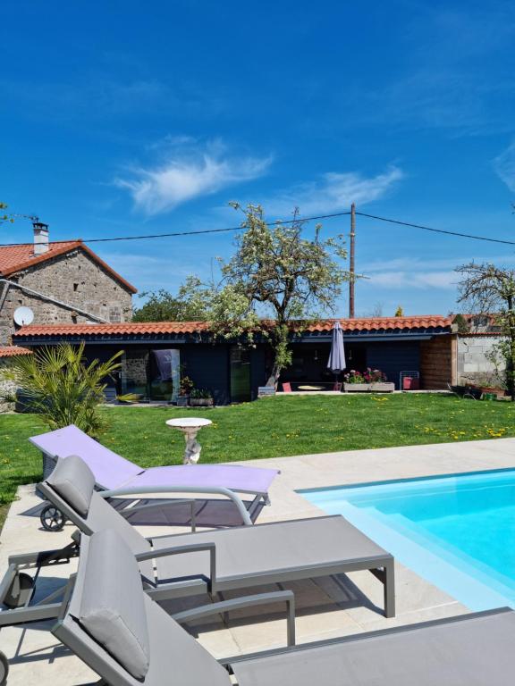 a villa with a swimming pool and a house at Au pool house de la Faye avec jacuzzi in Saint-Romain-Lachalm
