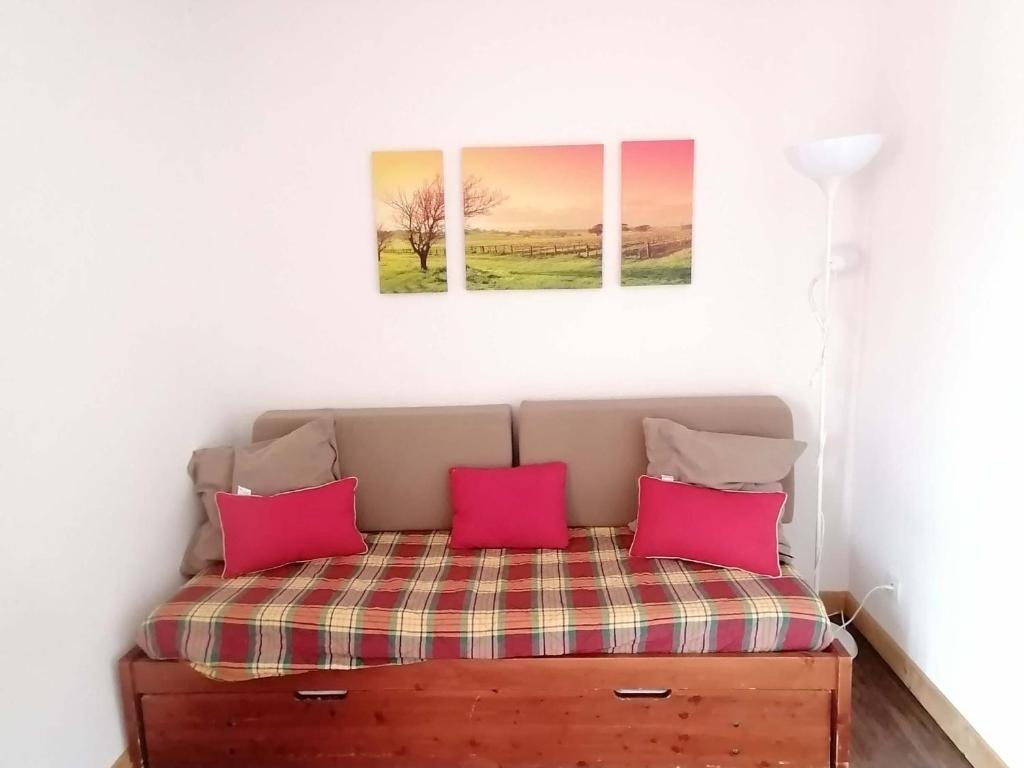 a bed in a room with two paintings on the wall at Appartement Saint-François-Longchamp, 1 pièce, 2 personnes - FR-1-635-32 in Saint-François-Longchamp