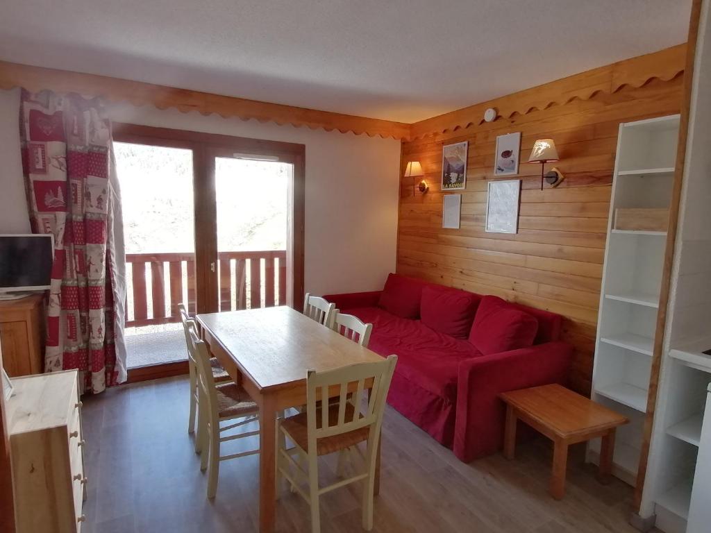 a living room with a red couch and a table at Appartement Saint-François-Longchamp, 3 pièces, 6 personnes - FR-1-635-61 in Saint-François-Longchamp