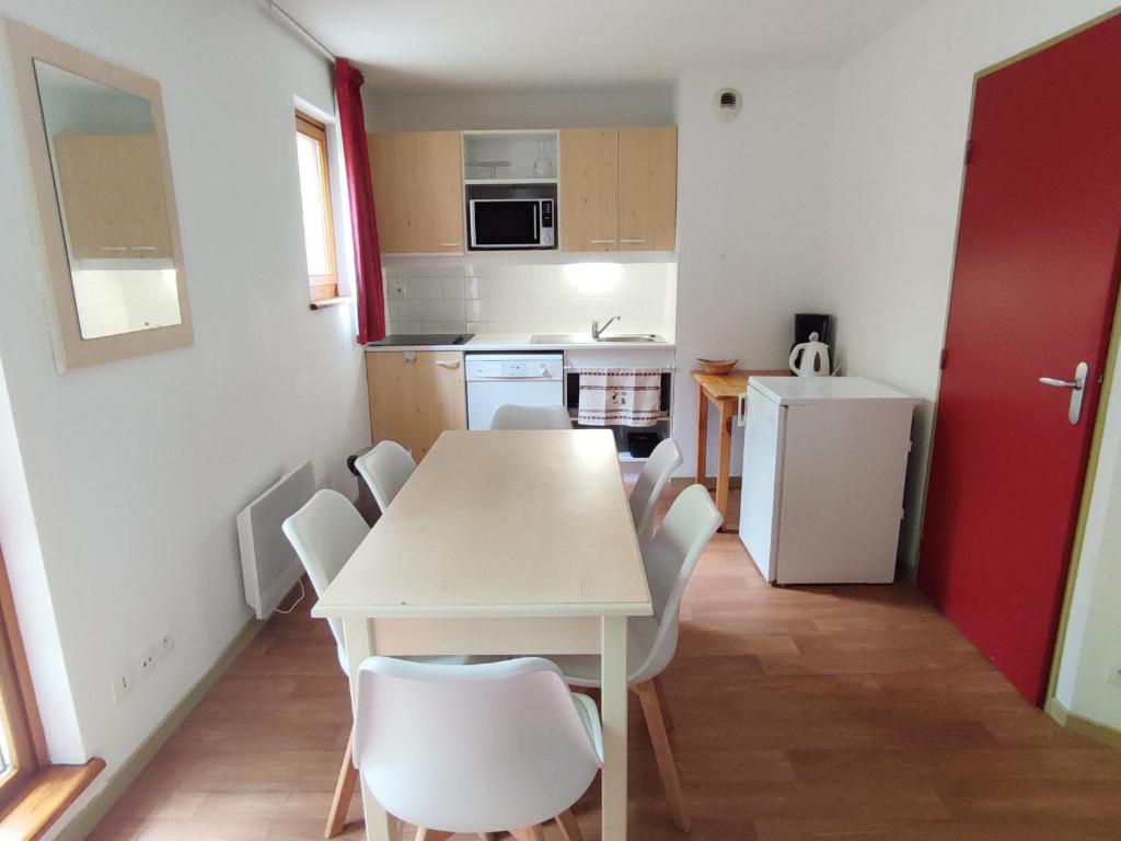 uma cozinha com uma mesa branca e cadeiras brancas em Appartement Saint-François-Longchamp, 3 pièces, 8 personnes - FR-1-635-84 em Saint-François-Longchamp