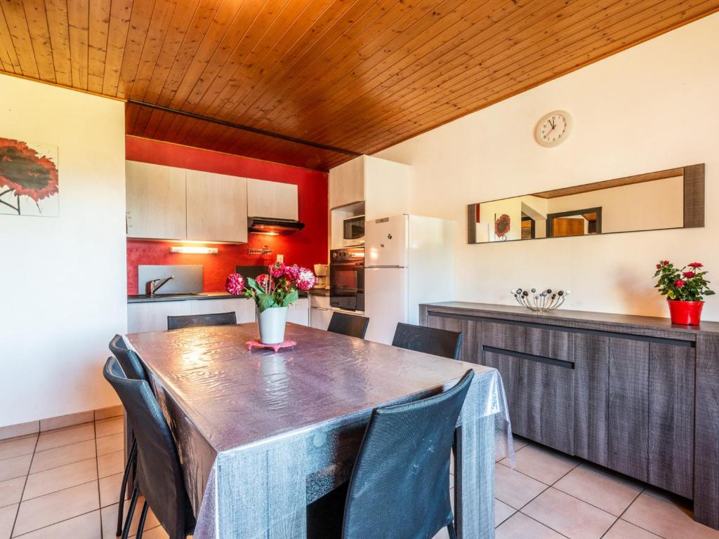 une cuisine avec une grande table et des chaises en bois dans l'établissement Appartement cozy avec Wi-Fi, parking et animaux admis - FR-1-671-72, aux Gets