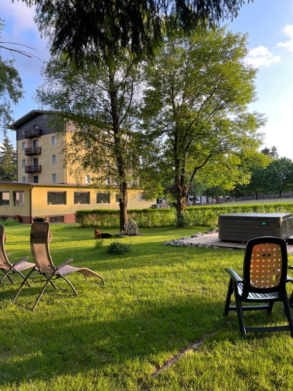 福爾加里亞的住宿－Hotel Rech-Hof Sayonara，公园草地上的三把椅子