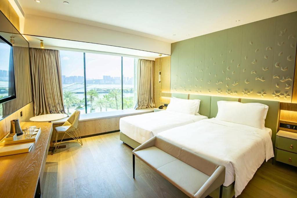 Postel nebo postele na pokoji v ubytování YOHO Treasure Island Hotel