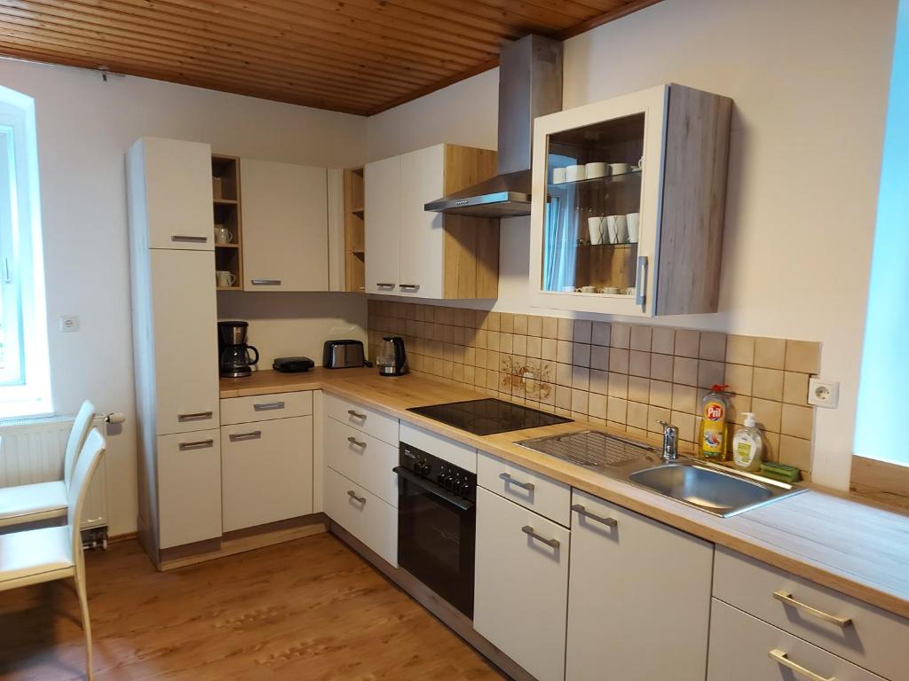 a kitchen with white cabinets and a sink at Mariazell Salza Haus in Gusswerk