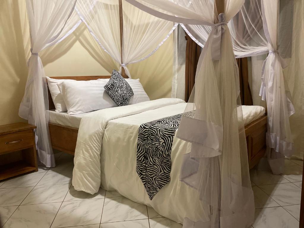 a bedroom with a bed with mosquito netting at ULTRA HOME-Private House in Arusha