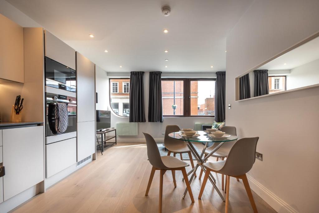 cocina y comedor con mesa y sillas en BRAND NEW Apartments with FREE Parking and WIFI! en Staines