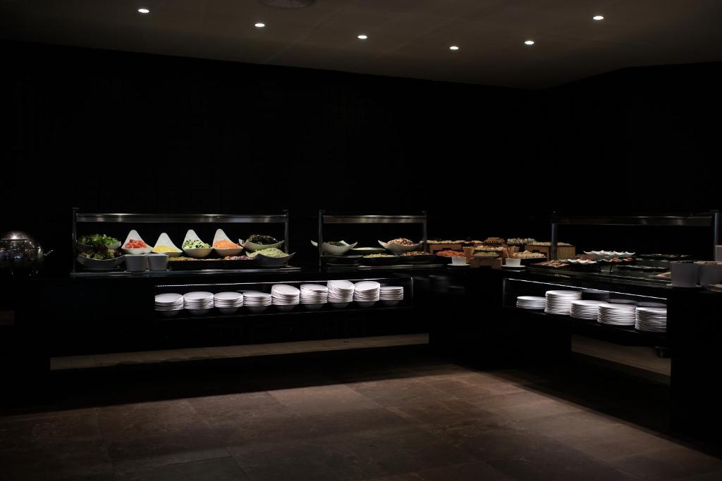 a black room with a buffet of food on display at Prinsotel La Dorada & Spa in Playa de Muro