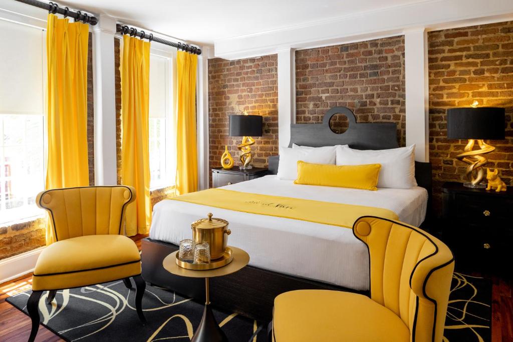 a hotel room with a bed and two chairs at The Vendue, Downtown Art Hotel in Charleston