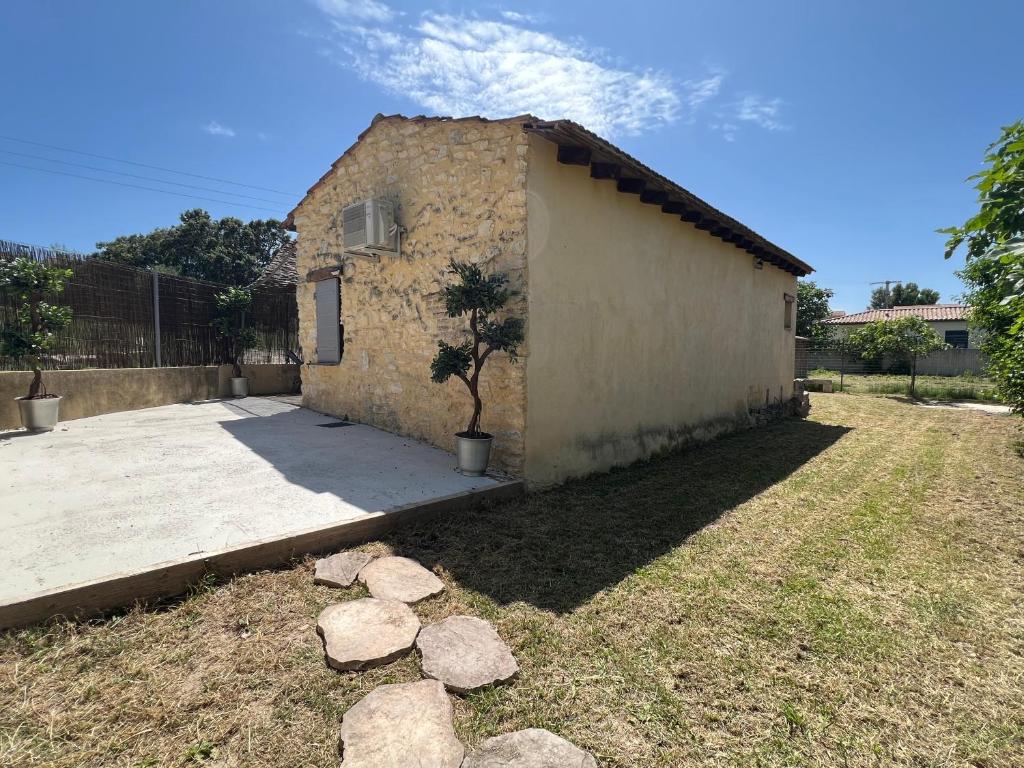 ein Gebäude mit einem Baum davor in der Unterkunft Cabanon provençal in Rochefort-du-Gard