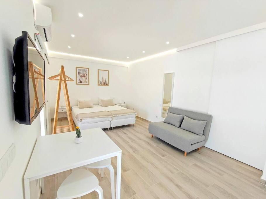 a white living room with a couch and a bed at Lovely Terrace Studio Baixa Faro in Faro