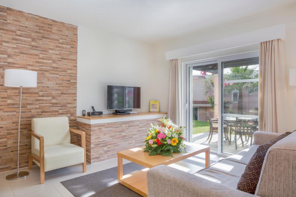 a living room with a couch and a tv at Vilar do Golf in Quinta do Lago