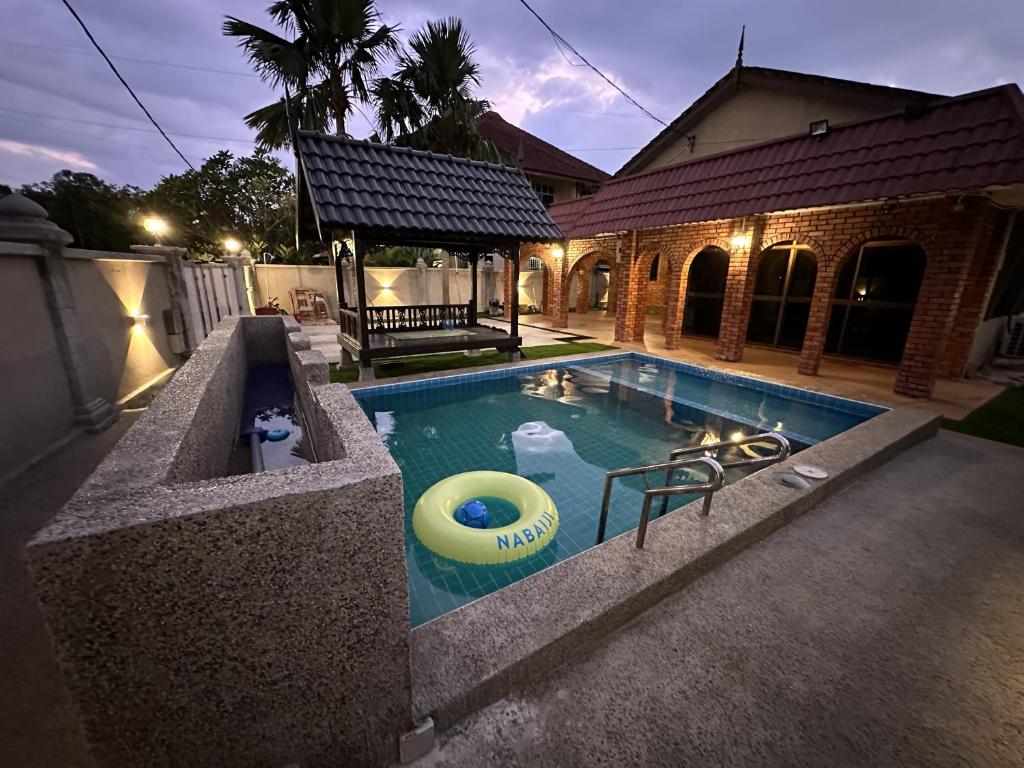 a swimming pool with a yellow frisbee in it at Mawar 23 Chendering with Private Pool in Kuala Terengganu