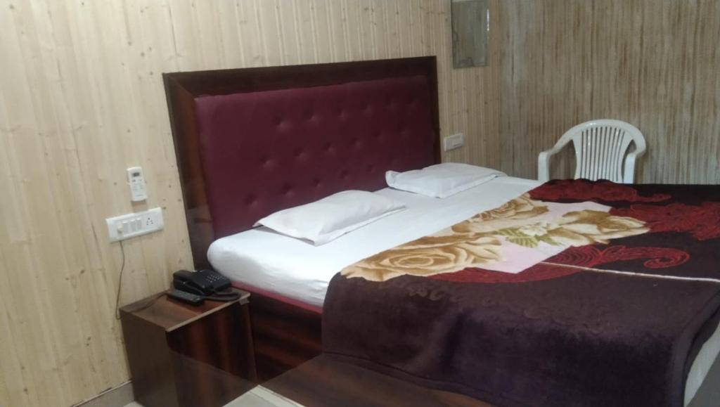 a bedroom with a large bed with a red headboard at Hotel Host near Taj in Agra