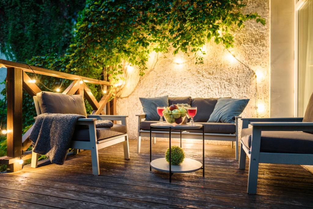 patio z kanapą, krzesłami i światłami w obiekcie Close to nature - Nida Apartments w mieście Nida