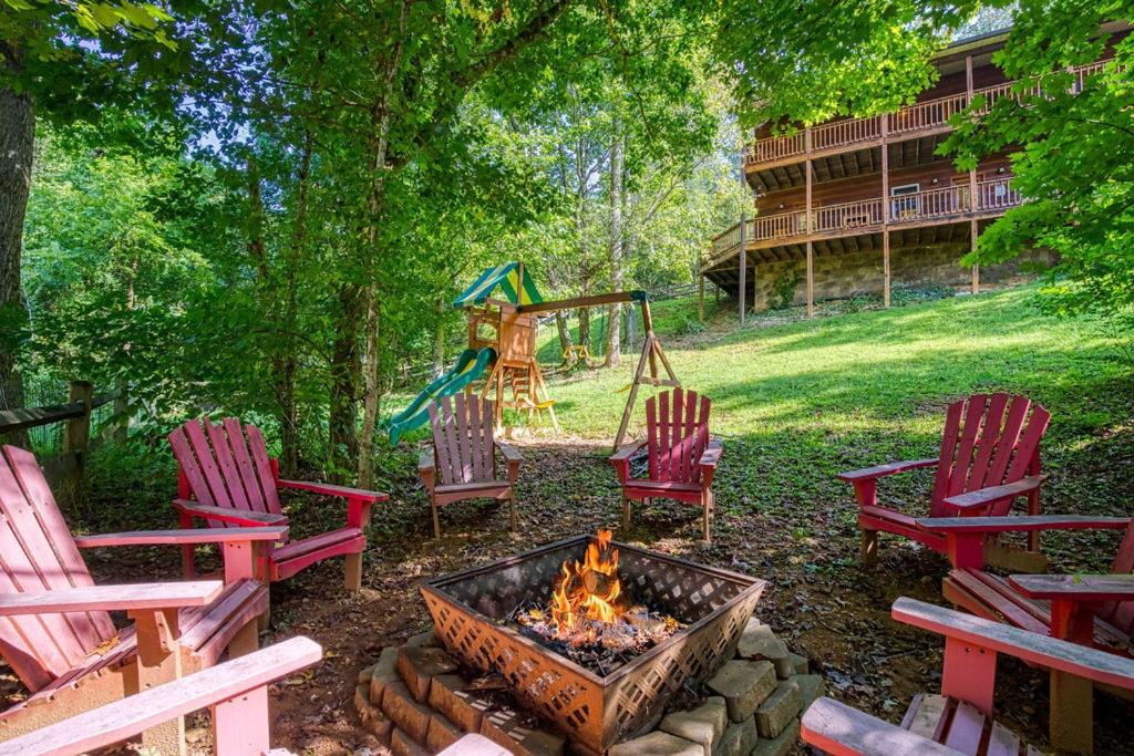 a fire pit with chairs and a swing and a playground at Paradise Found, Hot Tub, Mtn Views, Game Room, 560 FREE tickets each paid day! in Sevierville
