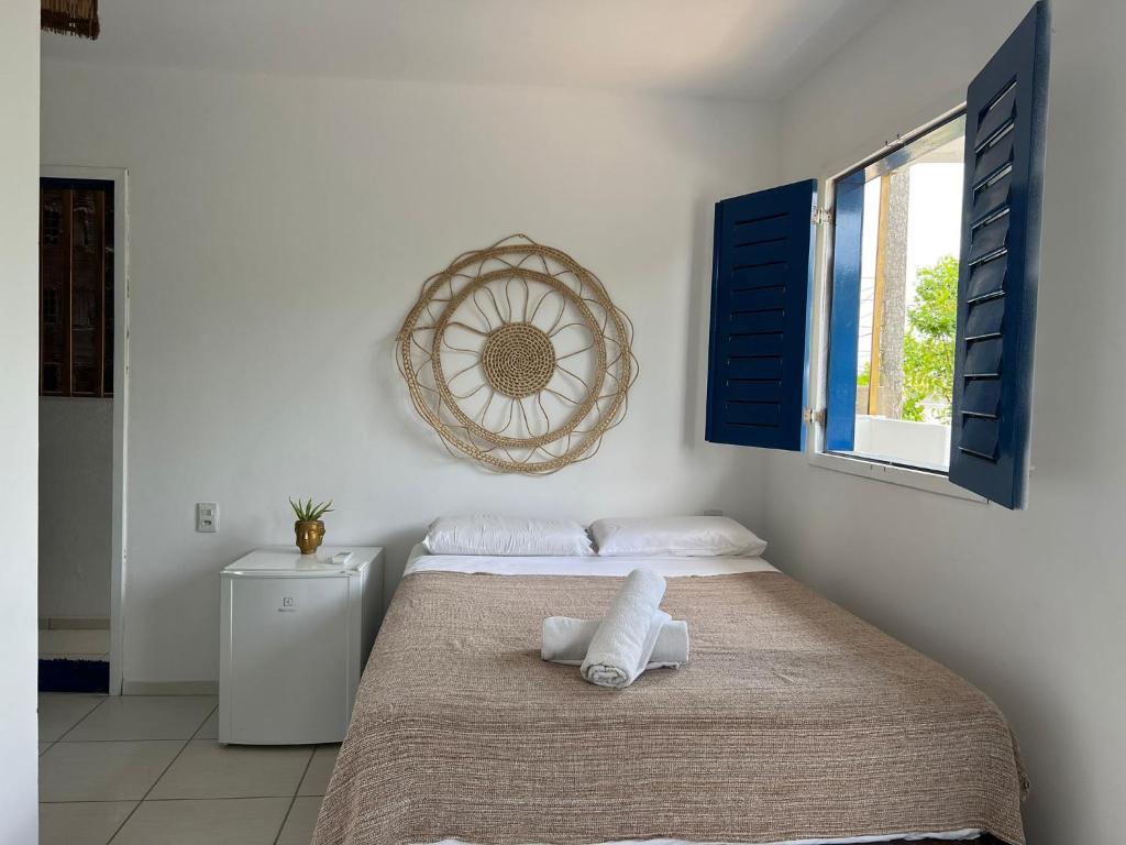 Un dormitorio con una cama con una toalla. en AZULIKITE en Jericoacoara