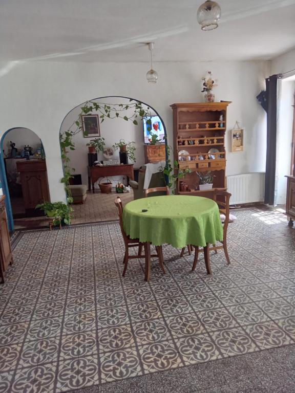 - un salon avec une table et des chaises vertes dans l'établissement aurelie, à Saint-Pierre-le-Moûtier