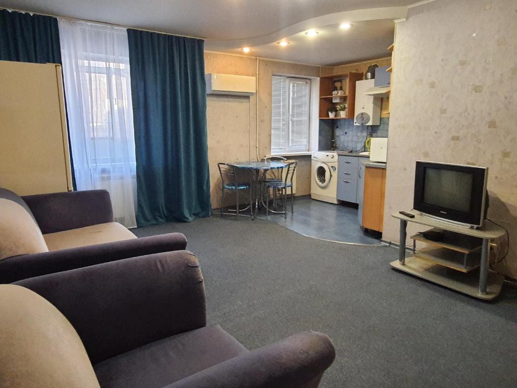sala de estar con sofá y TV y cocina en Aparthotel VictoryHome, en Krivoy Rog